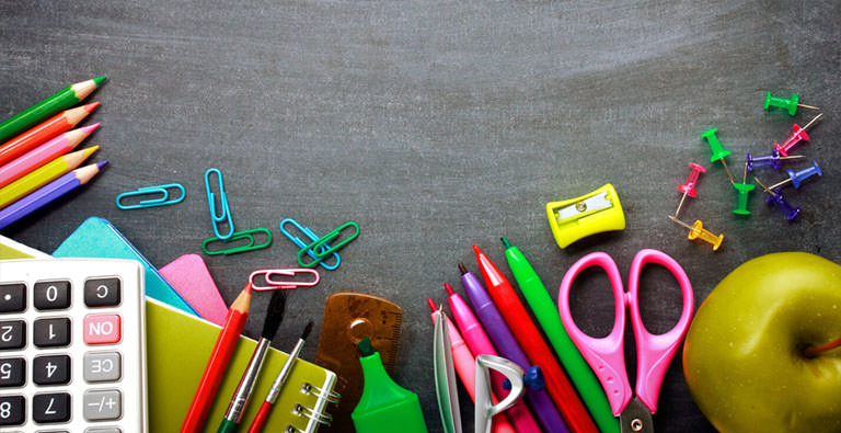Schere und bunte Schreibutensilien und Apfel auf einem Tisch