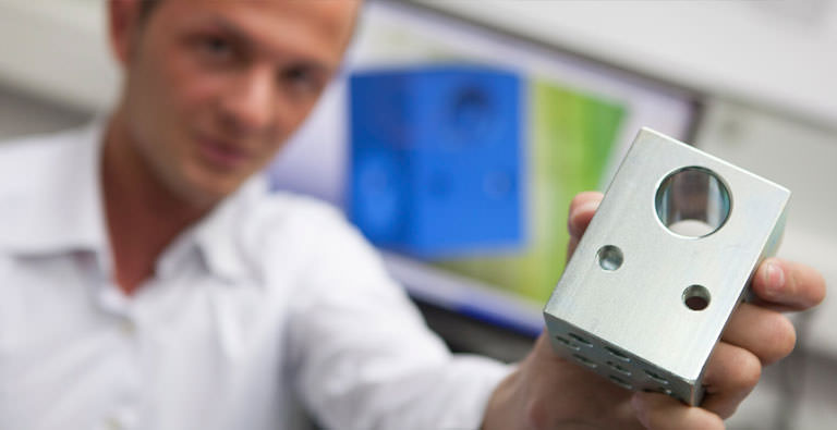 Mann zeigt Industrieprodukt ins Bild