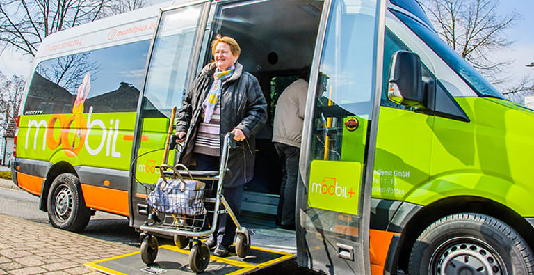 Person mit Rollator steigt aus Bus aus