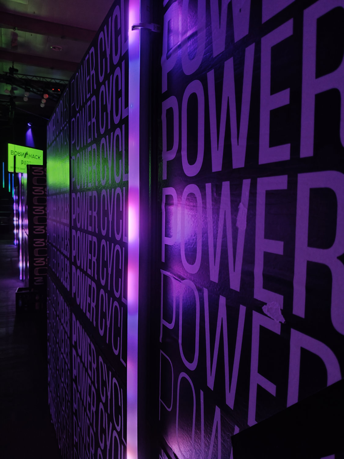 Nahaufnahme einer lila beleuchtenden Wand im Congress Center, auf dem ganz oft "Powercycles" steht