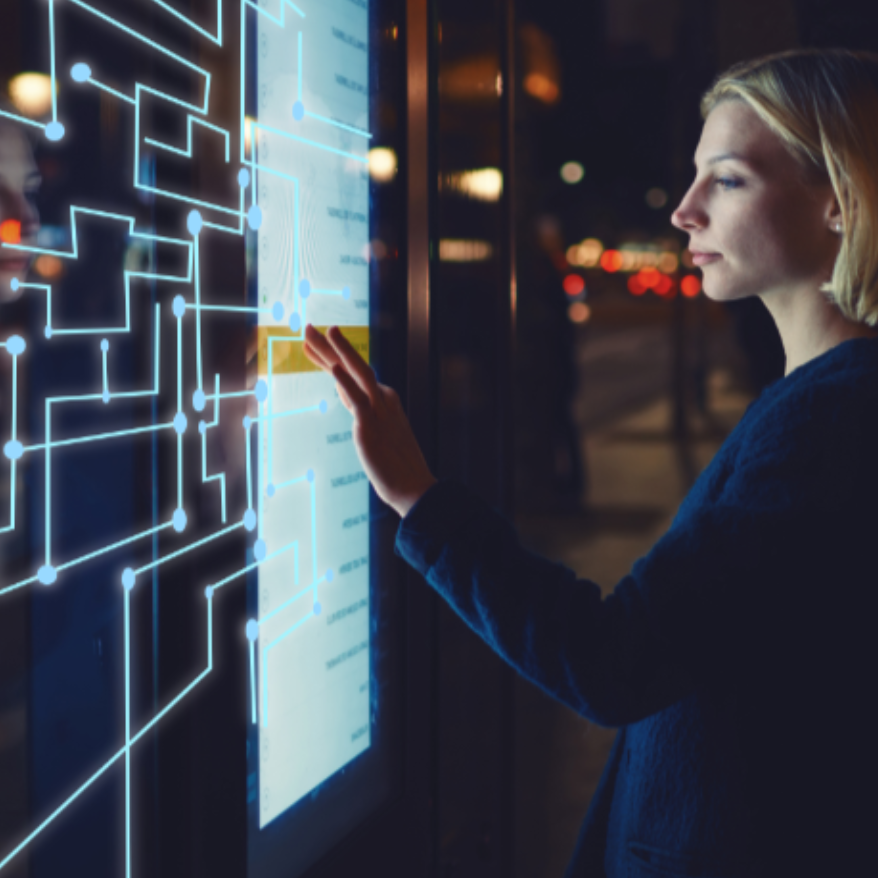 Eine Person interagiert mit einem großen Touchscreen, auf dem eine digitale Schnittstelle mit leuchtenden, schaltkreisähnlichen Grafiken angezeigt wird. Die Umgebung scheint städtisch und nachts zu sein, im Hintergrund sind verschwommene Lichter der Stadt zu sehen.