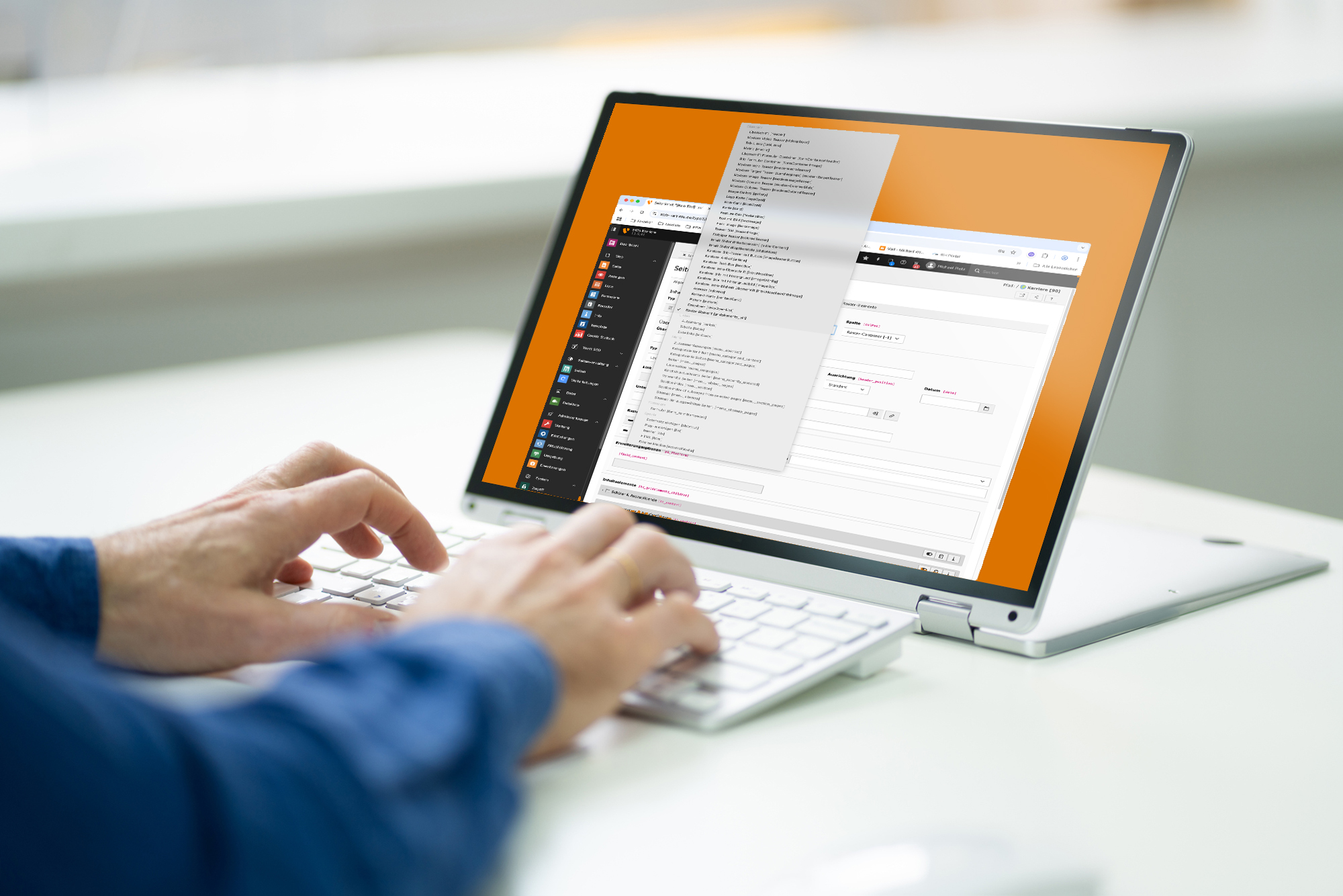 Person, die auf einem weißen Laptop tippt, auf dessen Bildschirm mehrere Fenster geöffnet sind, die die TYPO3-Oberfläche zeigen.