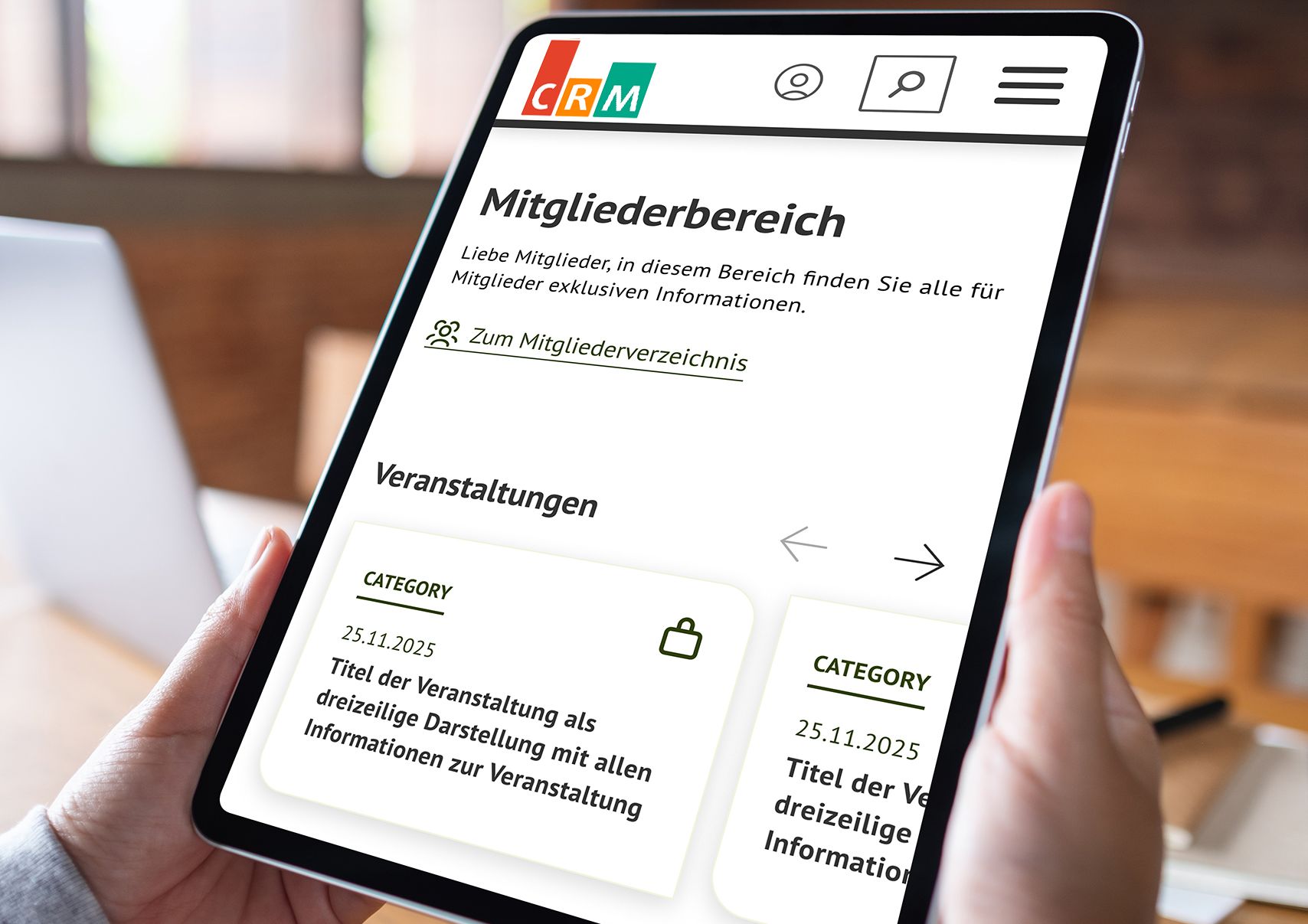 Eine Person hält ein Tablet, auf dem der Mitgliederbereich einer Website und Veranstaltungshinweise angezeigt werden.