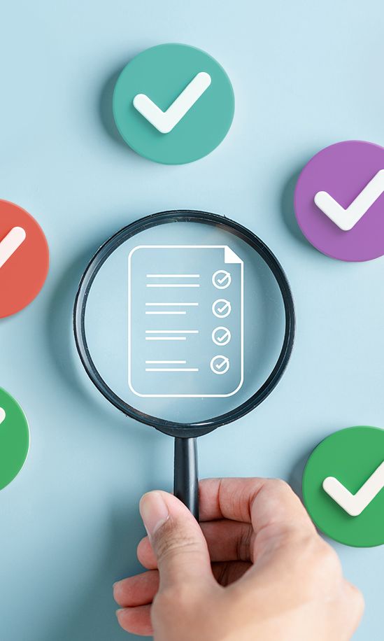 Eine Hand hält ein Vergrößerungsglas über eine Checkliste, umgeben von bunten Check-Haken auf blauem Hintergrund.
