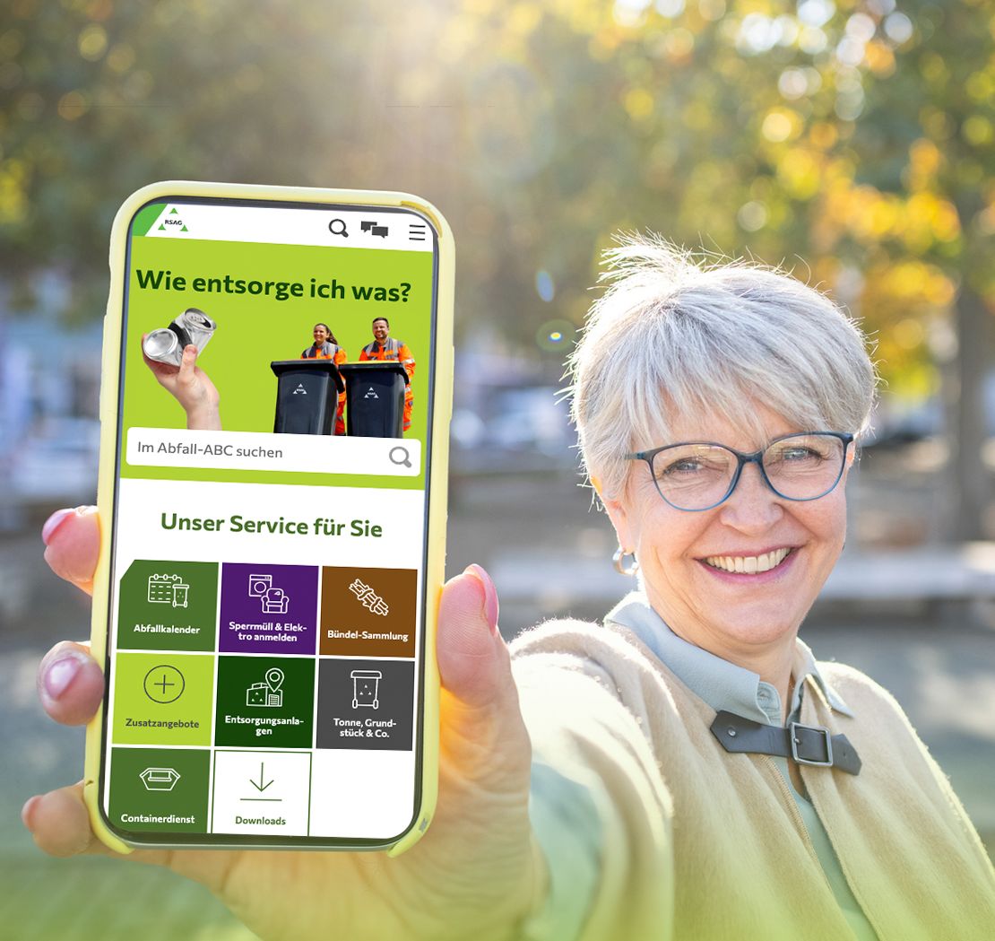Lächelnde Frau im Freien, die ein Smartphone hochhält, auf dem die RSAG-App angezeigt wird.